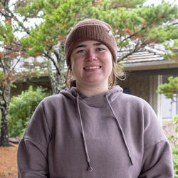 A person in a sweatshirt and wearing a knitted cap. 